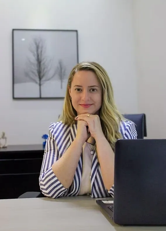 Psicóloga Luana Hochmann em atendimento por videochamada no consultório.